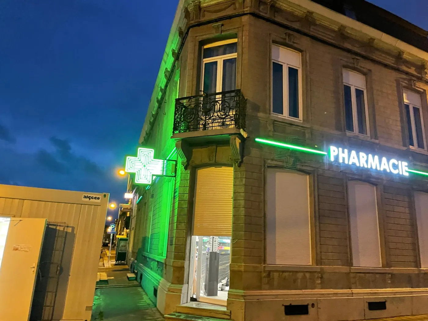 Façade de pharmacie rénovée par Novaris avec croix verte et enseigne lumineuse