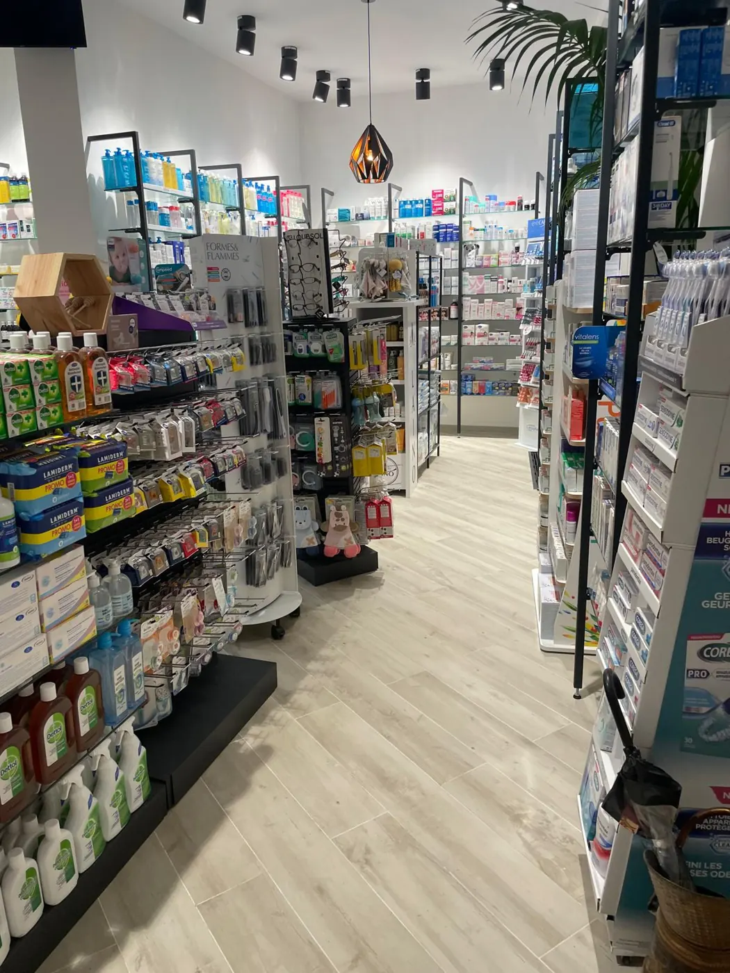 Intérieur de pharmacie rénovée : allée, linéaires et éclairage