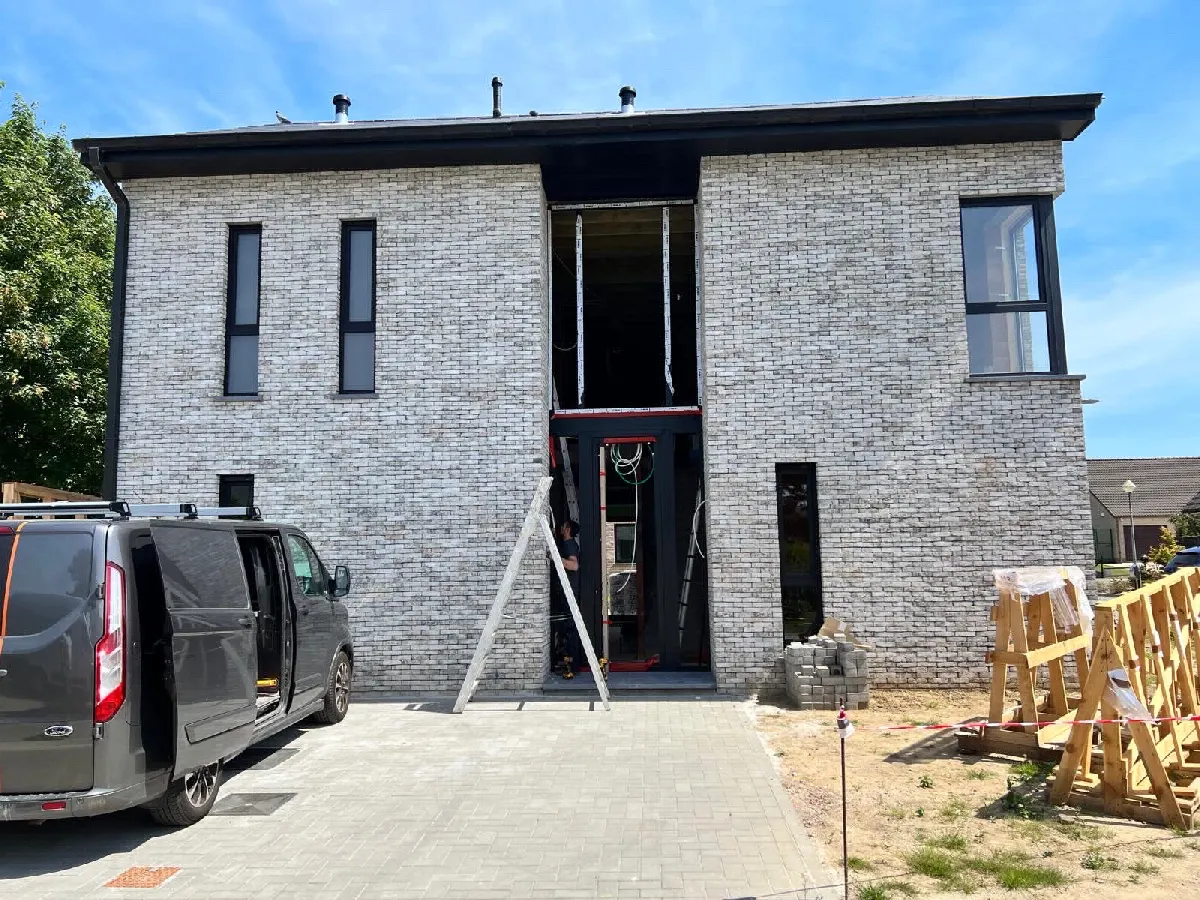 Façade de maison en brique claire équipée de châssis aluminium